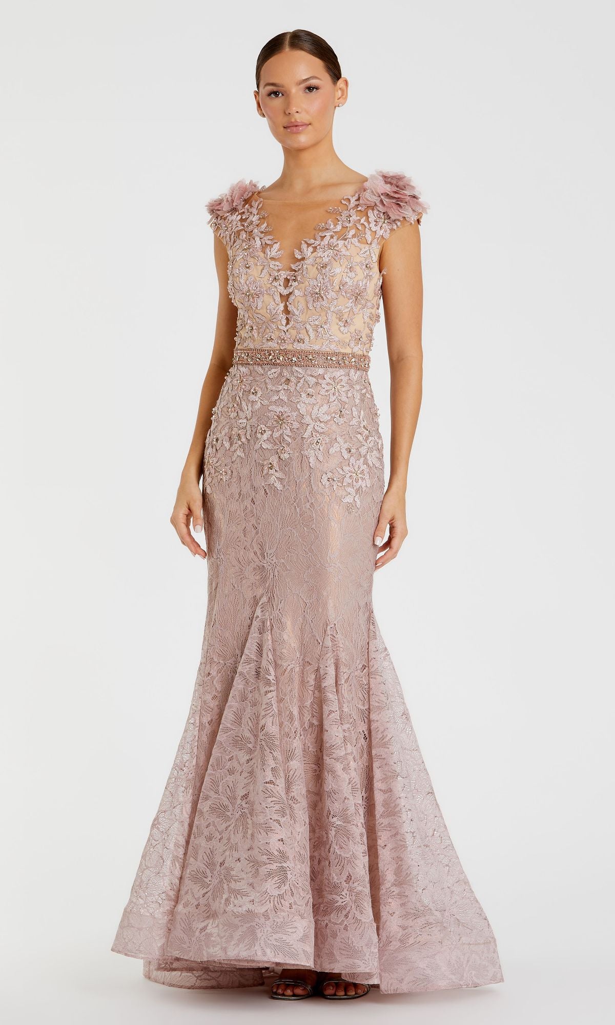 A woman wears the Mac Duggal 79368 cap-sleeve long formal dress in mauve, featuring floral embroidery, a deep V-neckline, and feathered shoulder accents, standing against a plain background.